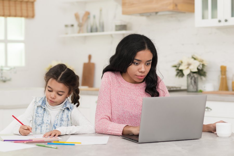 Mom working and daughter doing her school work